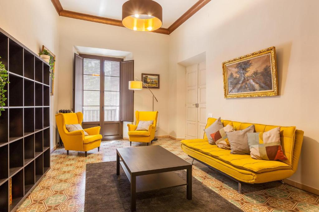 sala de estar con sofá amarillo y 2 sillas en Apartament Merlot, en Vilafranca del Penedès