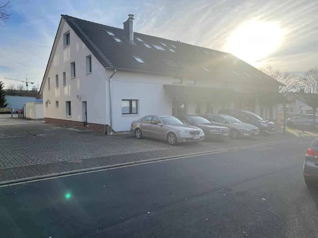 a group of cars parked next to a white building at Bed4You Gästehaus 1 in Bergshausen