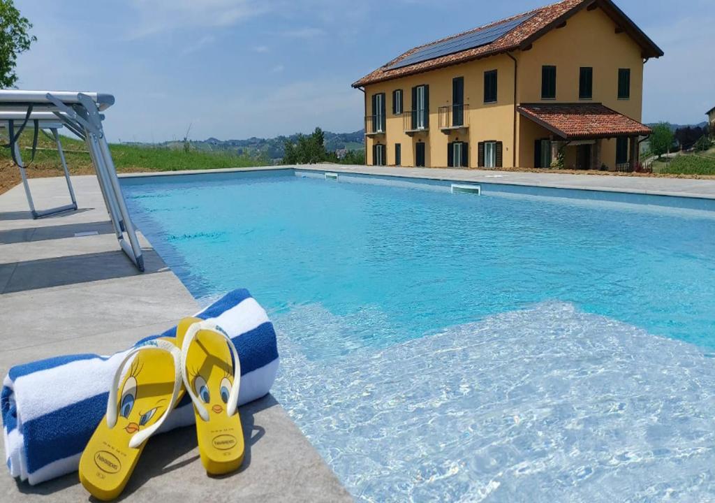 para żółtych klapek siedzących obok basenu w obiekcie Al Tirabusòn Country House w mieście Nizza Monferrato