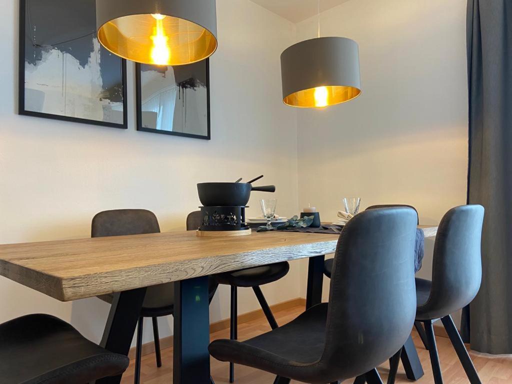 een eettafel met stoelen en 2 verlichting bij Apartment Via Surpunt - Florentina- 3 Rooms in St. Moritz