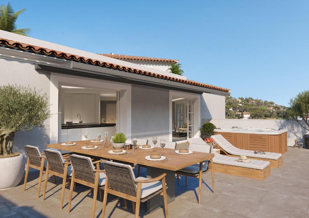 un patio avec une table et des chaises en bois dans l'établissement Appartement Massimo, à Sainte-Maxime