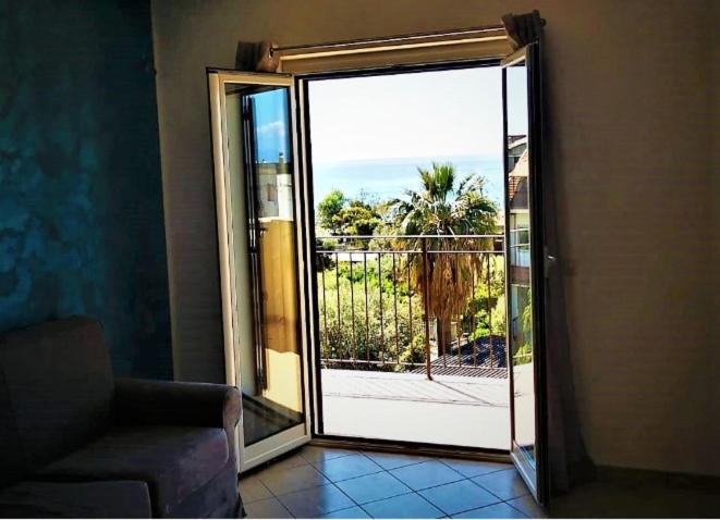 a sliding glass door with a view of the ocean at CASA VIA ALVARO in Roccella Ionica