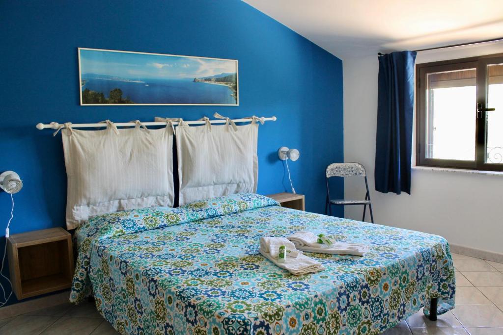 Schlafzimmer mit einem Bett mit blauer Wand in der Unterkunft Casa Nicotìria a 50mt dal mare in Nicotera Marina