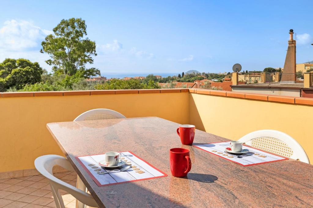 a table with two cups on top of a balcony at La Casa di Lady in Ceriale
