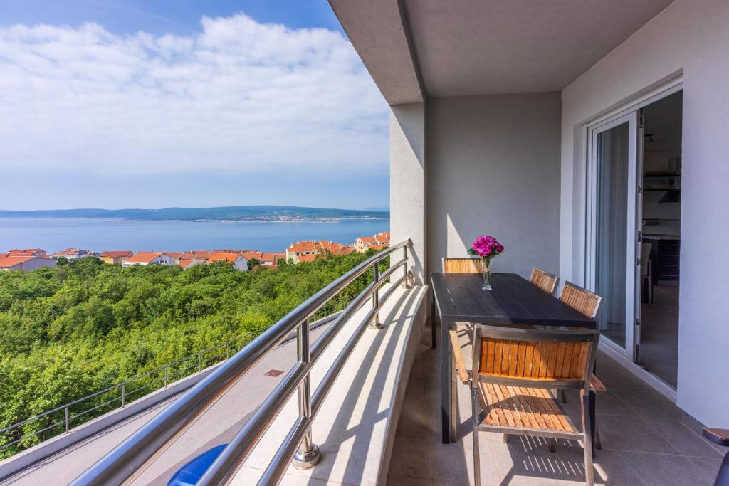d'un balcon avec une table et des chaises et une vue sur l'océan. dans l'établissement Apartments Andrea & Sander, à Crikvenica