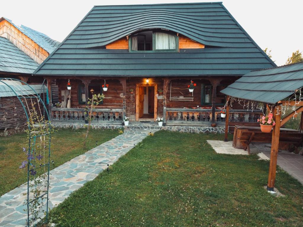 une maison avec un toit en gambrel et une cour dans l'établissement Casuta din dumbrava, à Ocna Şugatag