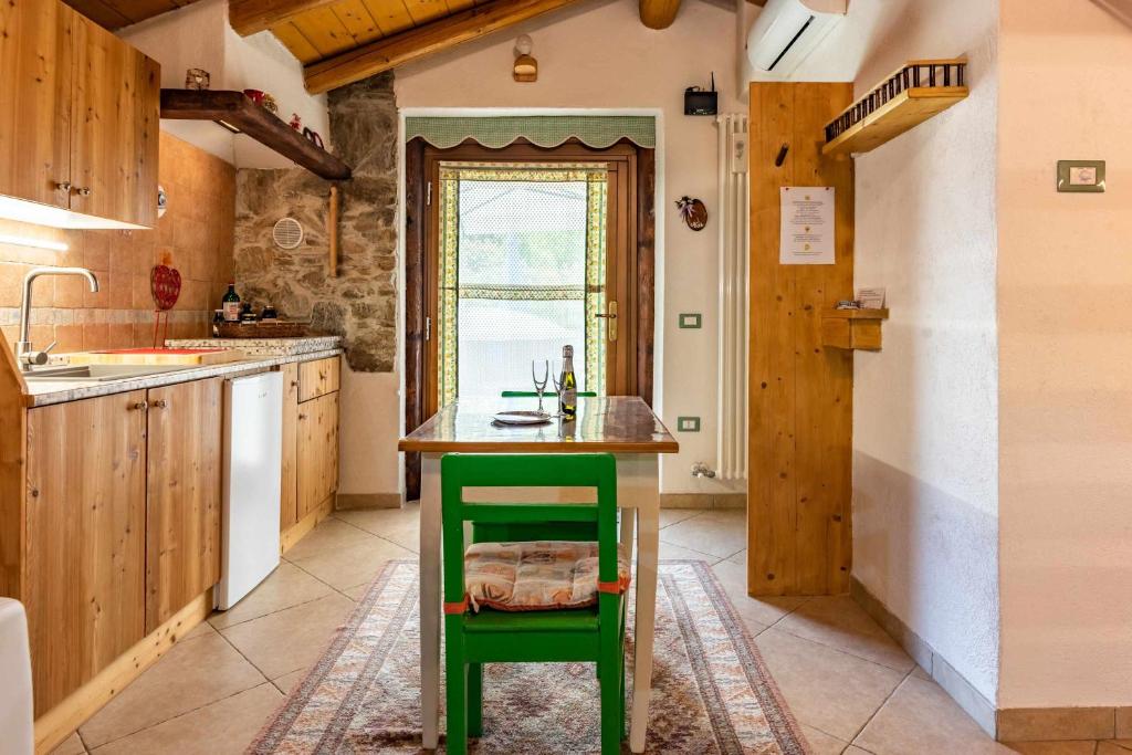 una cocina con una isla verde con un taburete verde en Chalet Altinate Tenna OSPITAR, en Tenna 