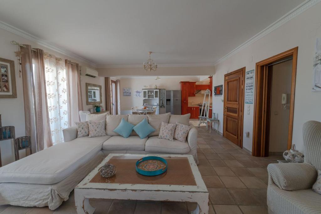 sala de estar con sofá blanco y mesa en Celine Deluxe Apartment en Lefkada