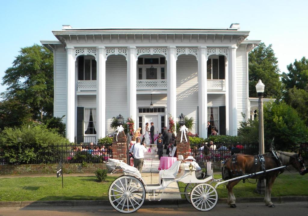 a horse drawn carriage in front of a white house at Shadowlawn Bed and Breakfast in Columbus