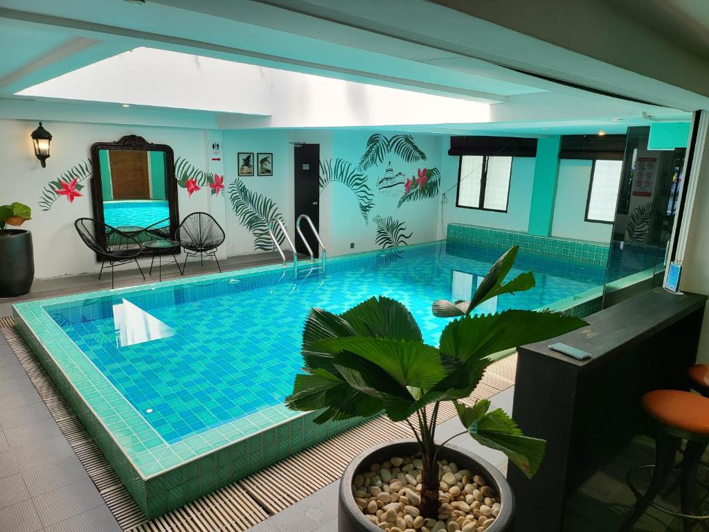 a large swimming pool in a house with a plant at The Boutique Residence Hotel in George Town