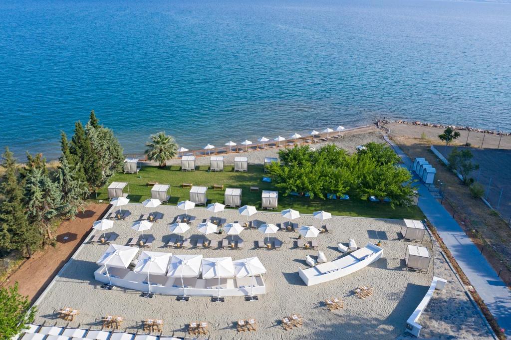 een uitzicht over een strand met stoelen en parasols bij Eretria Hotel & Spa Resort in Eretria