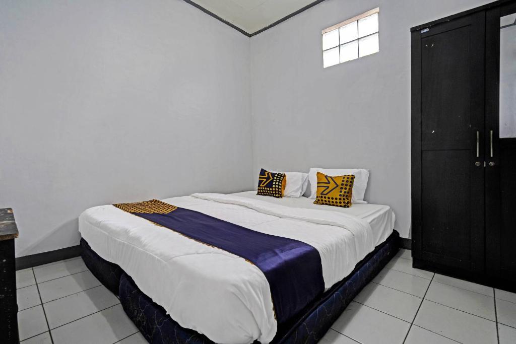 1 dormitorio con 1 cama grande en una habitación en SPOT ON 91190 Pondok Bijaksana, en Bandung