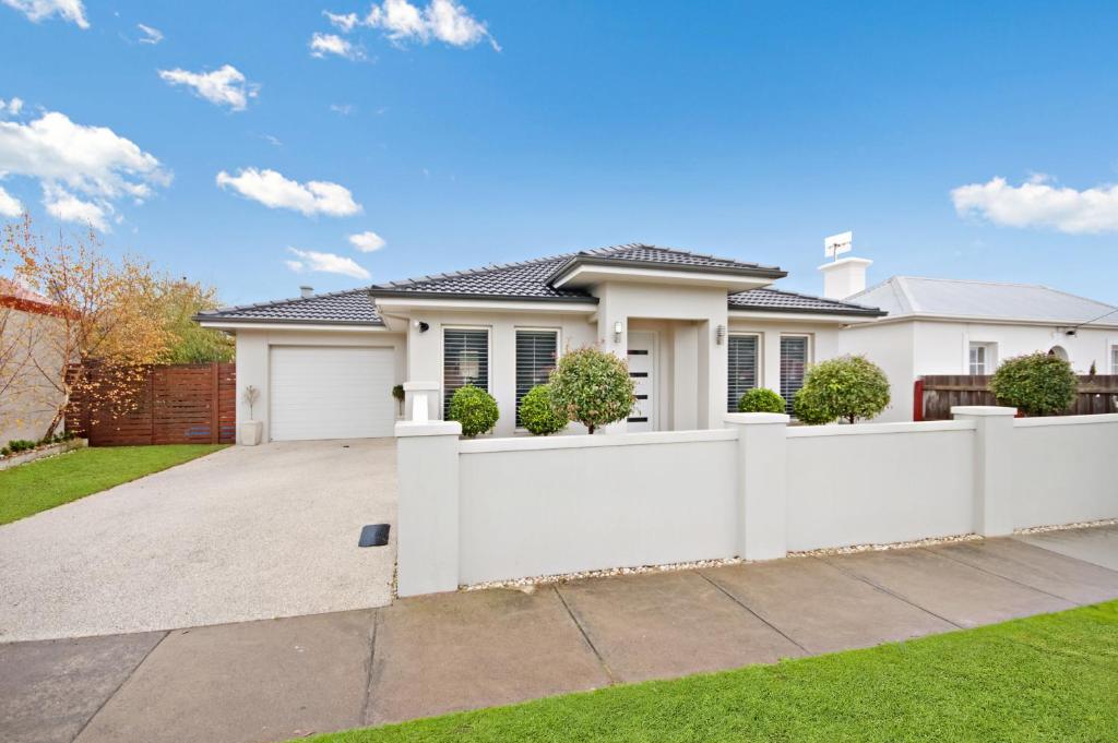 a white fence in front of a house at Central Warrnambool Townhouse in Warrnambool
