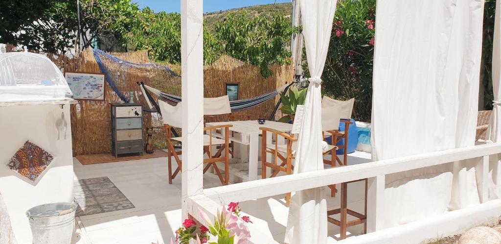 a balcony with a hammock and a table and chairs at La casa Rosa in Ponza