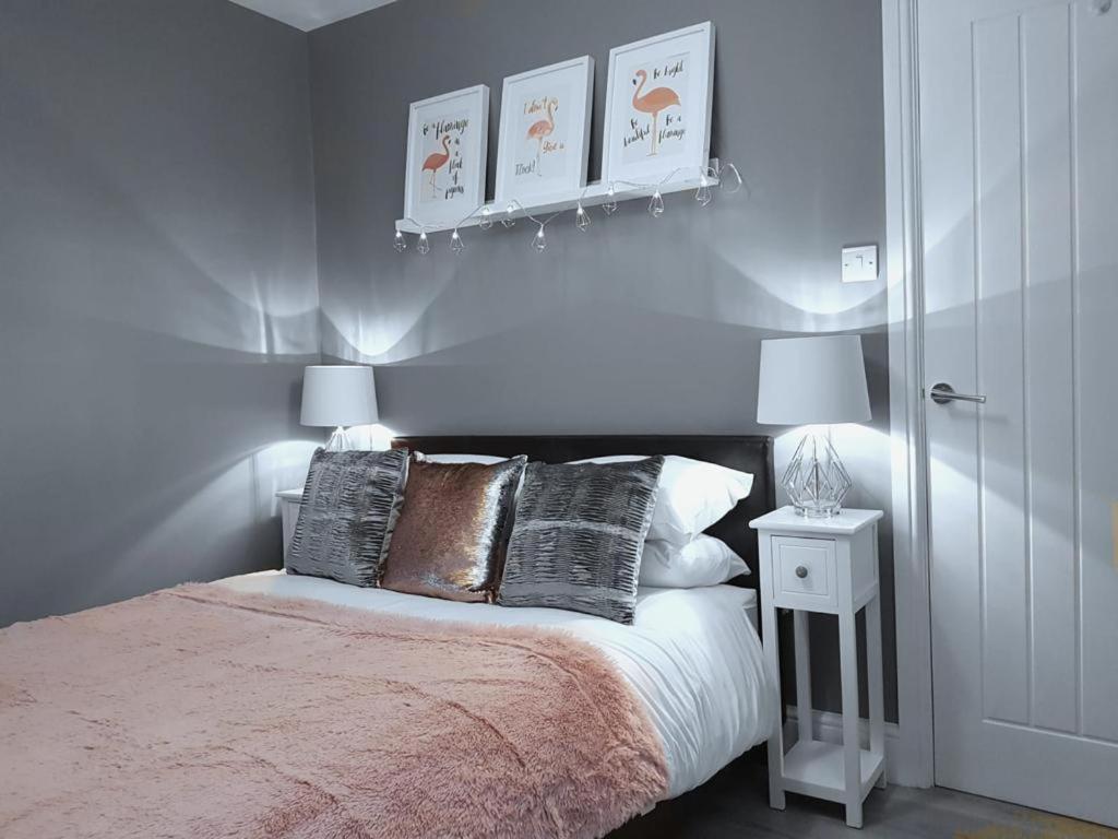 a bedroom with a bed with three pillows and two lamps at The Westside with Parking in York