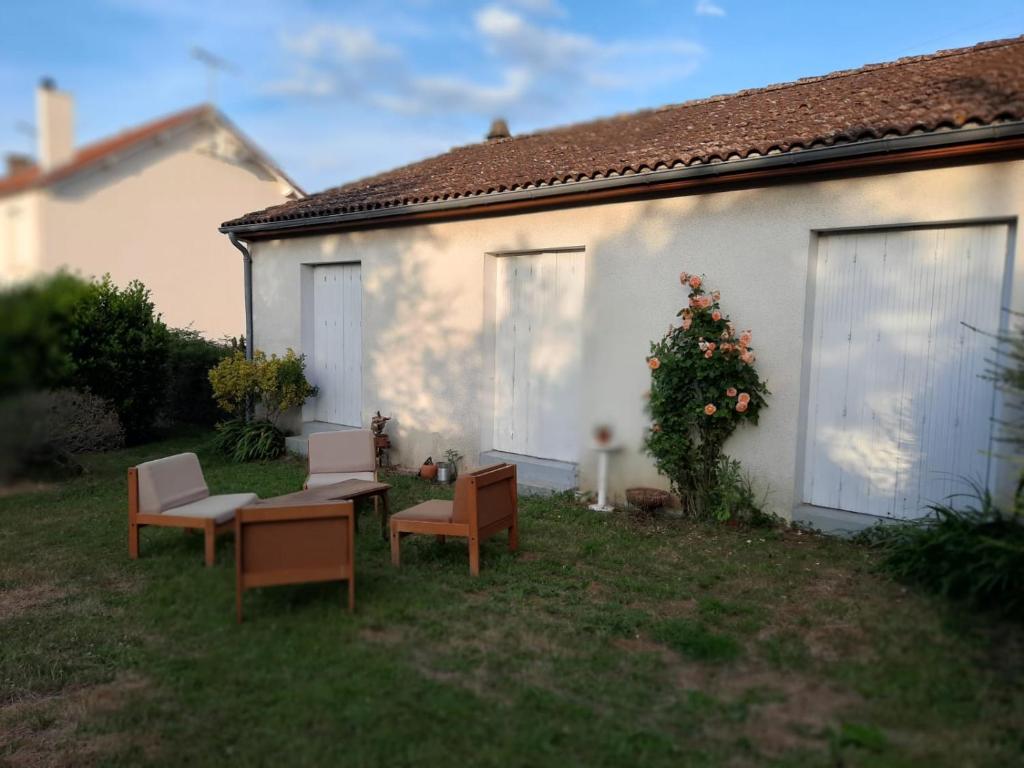 ein Haus mit Stühlen und einem Tisch im Hof in der Unterkunft Le Cerizay Gîte n°1 in Cerizay