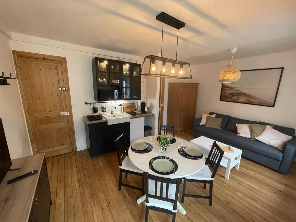 a kitchen and a living room with a table and chairs at Charmante Villa plein SUD 50m de la plage - Balcon vue latérale sur Mer - équipée de la Fibre, Wifi, internet in Mers-les-Bains