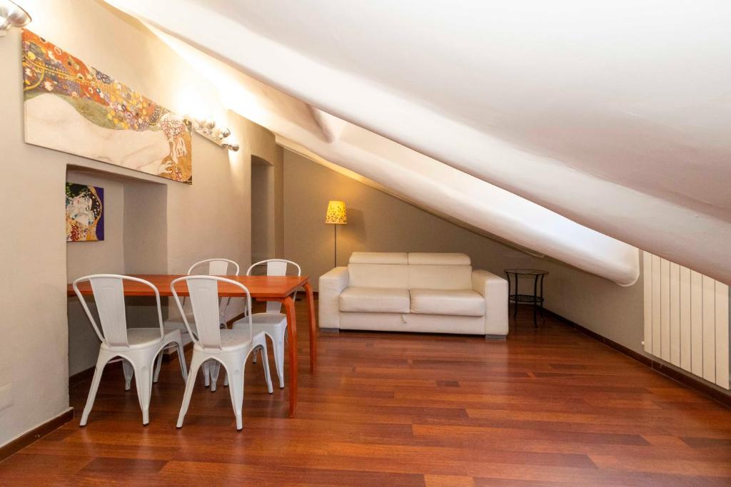 ein Esszimmer mit einem Tisch und weißen Stühlen in der Unterkunft San Salvario Apt with Balcony in Turin