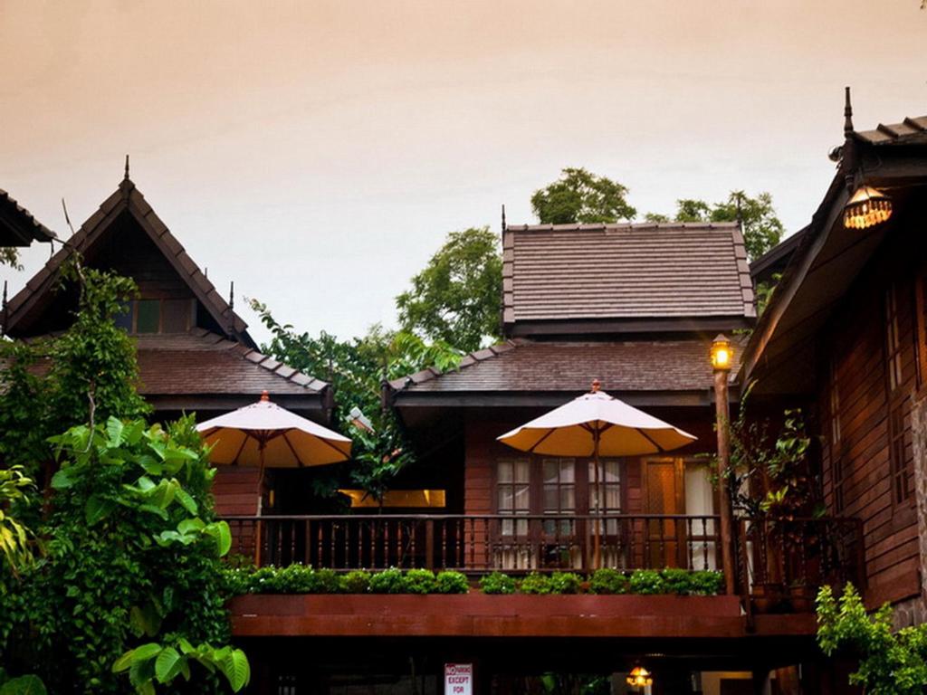 une maison avec deux parasols devant elle dans l'établissement Baantawan Guesthouse Pai, à Pai