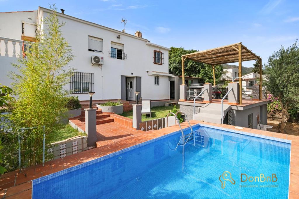 eine Villa mit einem Pool und einem Haus in der Unterkunft Casa de 2 dormitorios con piscina privada y desayuno incluido en Alhaurin in Alhaurín de la Torre