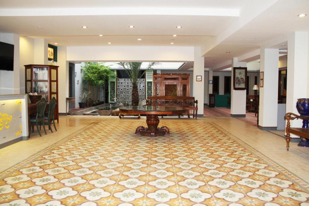 a living room with a table and a rug at Hotel Koening in Cirebon