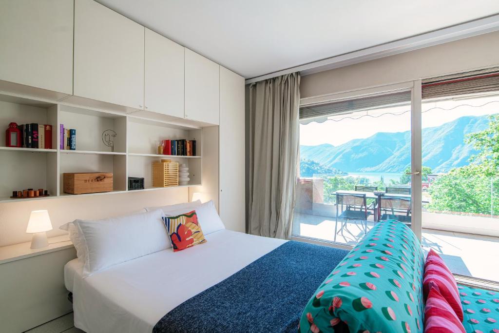 a bedroom with a bed and a large window at Panoramic Studio by Quokka 360 - open space apartment with terrace in Lugano