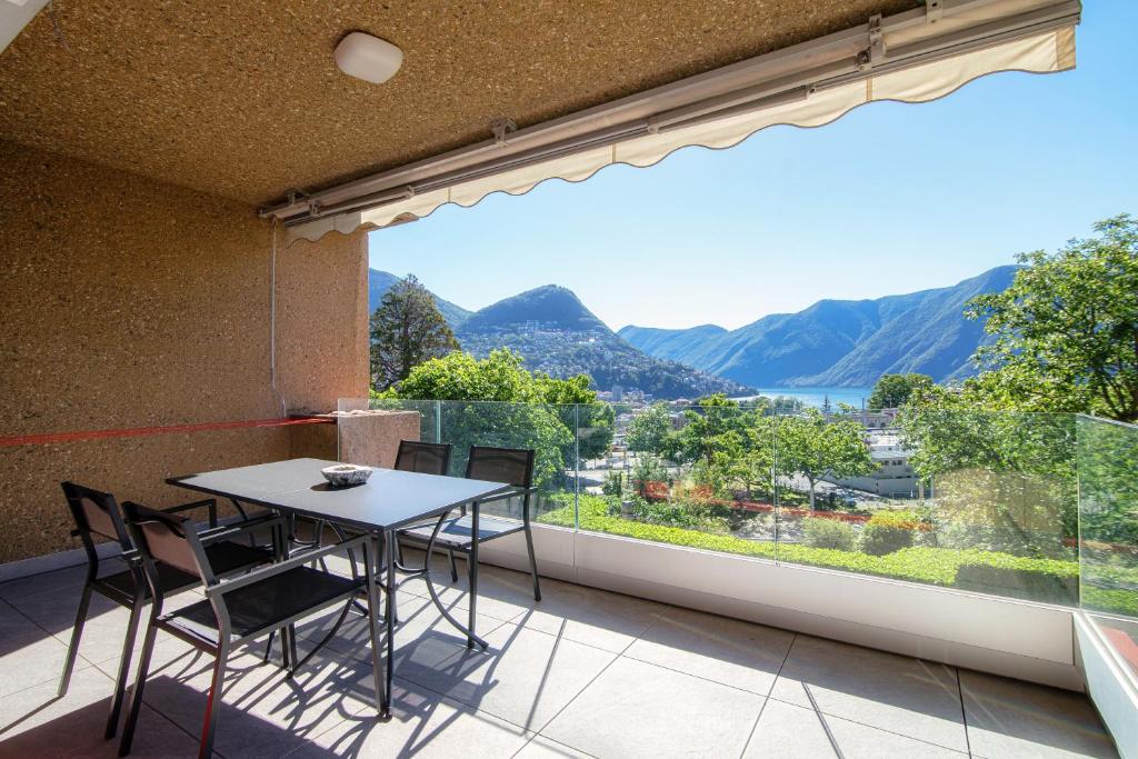 a balcony with a table and chairs and a large window at Panoramic Studio by Quokka 360 - Open Space Apartment with Terrace in Lugano