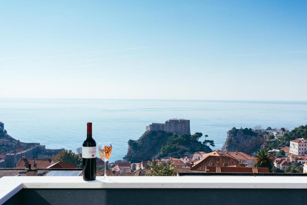 eine Flasche Wein und ein Glas auf einem Felsvorsprung in der Unterkunft Apartment Alius Ragusa Deluxe in Dubrovnik