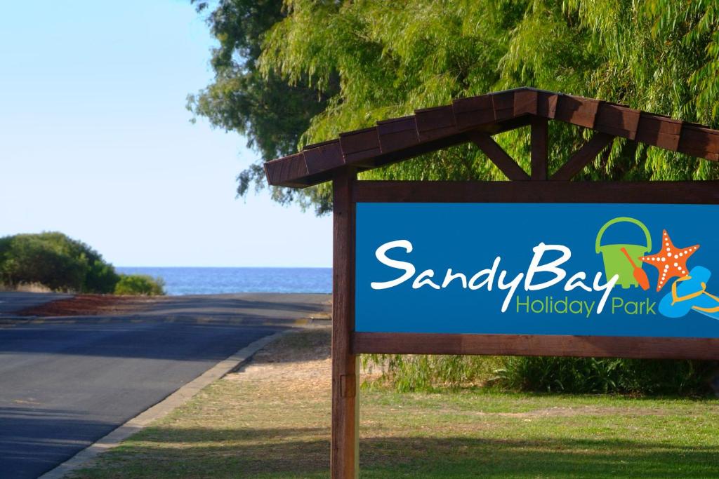 un panneau indiquant un village vacances dans une baie de sable dans l'établissement Sandy Bay Holiday Park, à Busselton