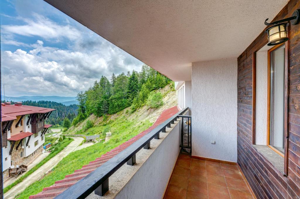 Elle comprend un balcon offrant une vue sur la montagne. dans l'établissement Colorful 2BD Apartment with Indoor Fireplace and Mountain View, à Pamporovo