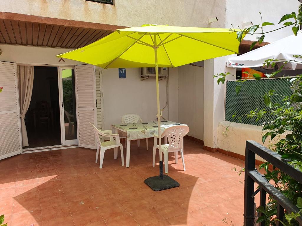 a table with a yellow umbrella on a patio at APARTAMENTO NATURISTA in Playas de Vera