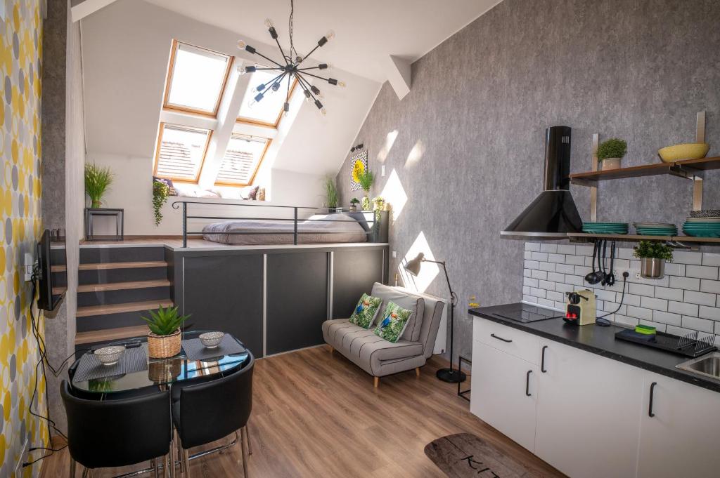 a kitchen and living room with a bed in a room at Palms Apartments Budapest in Budapest