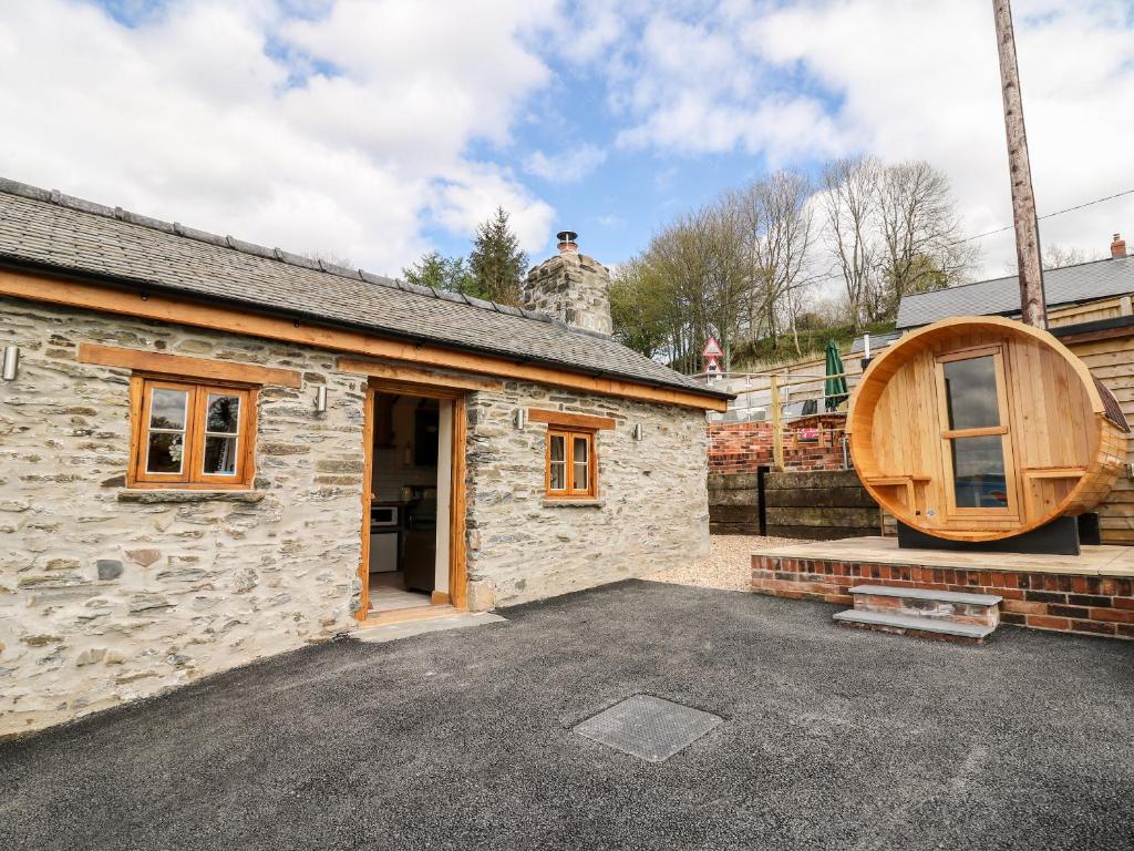 a barn conversion with a round window on the side of it at The Old Cobblers Shop in Llandrindod Wells