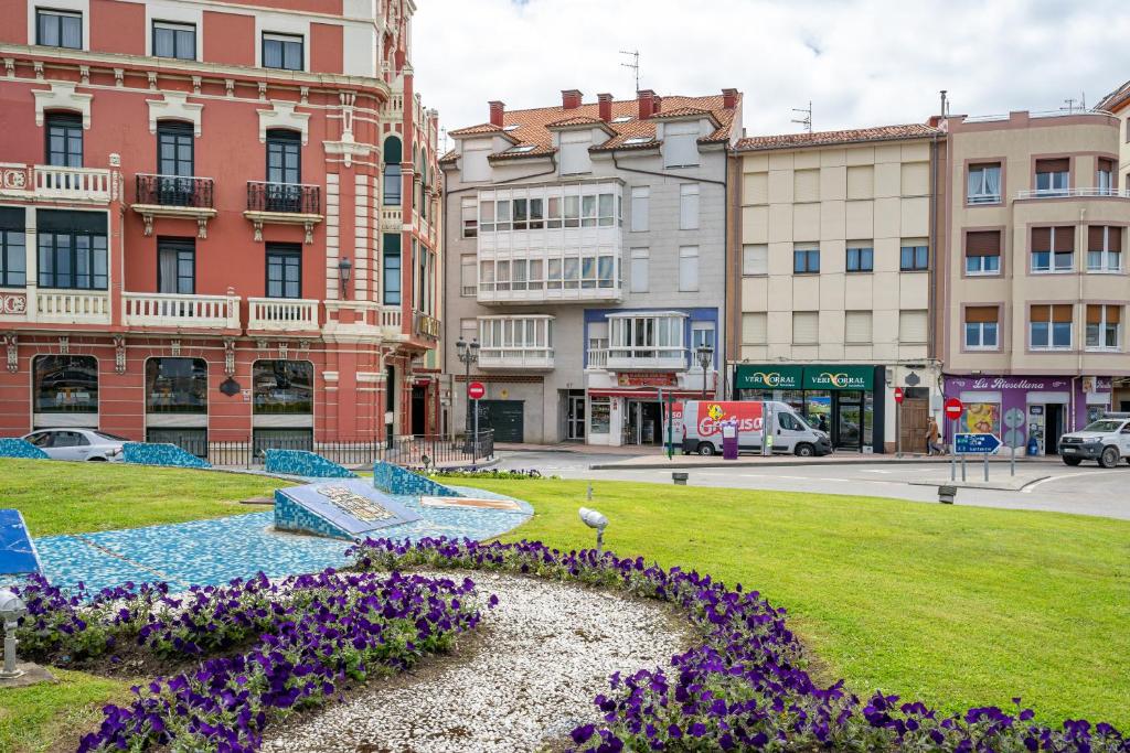 a park with purple flowers in the middle of a city at Apartamento riosella centro in Ribadesella