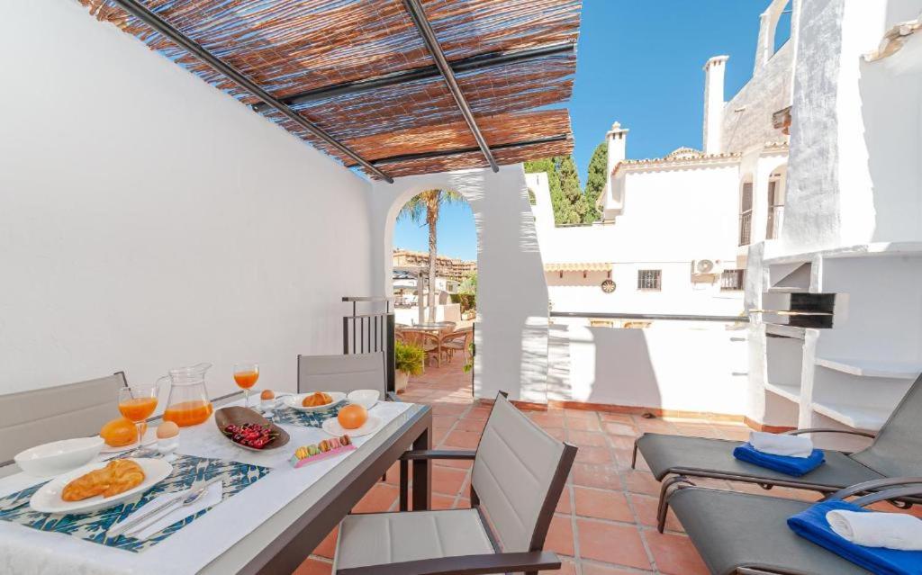 jadalnia ze stołem i krzesłami na patio w obiekcie Pueblo Evita w mieście Benalmádena