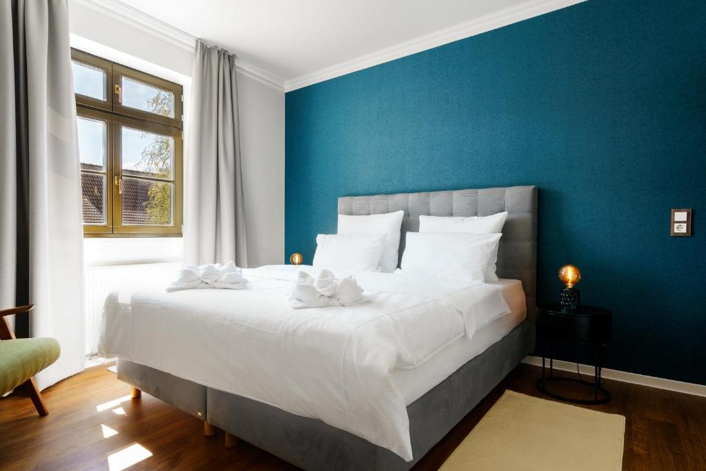 um quarto com uma cama grande e uma parede azul em Hotel Waren-Alte Warener Zeitung em Waren