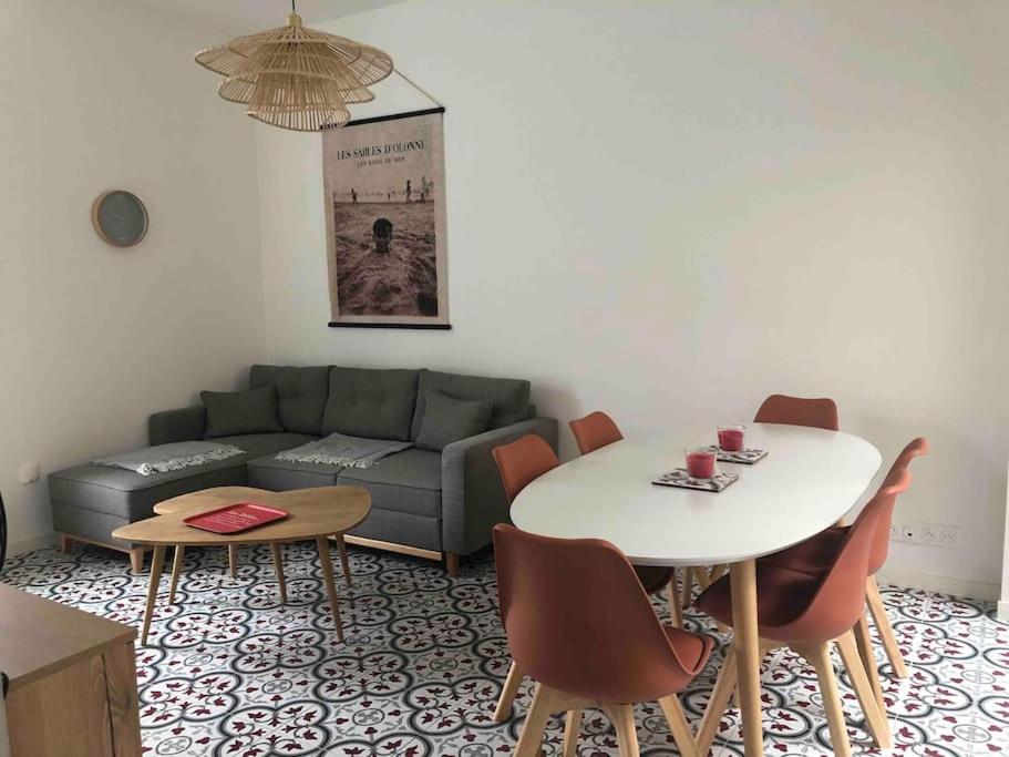 a living room with a couch and a table at Jolie maison de pêcheur ARAGO aux Sables d'Olonne in Les Sables-dʼOlonne