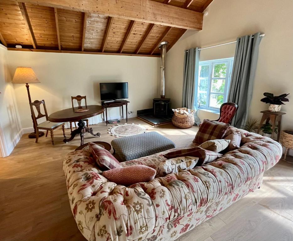 a living room with a couch and a table at The Billiard Room - Cosy Country Retreat in Abergavenny