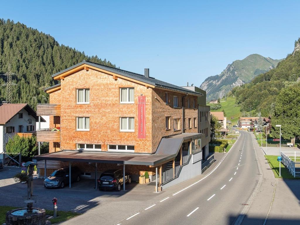 a large brick building on the side of a road at Chalet in der Alpine Lodge Klösterle am Arlberg in Klösterle
