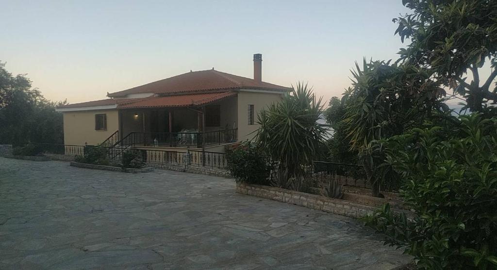 une maison avec une terrasse couverte et une clôture devant elle dans l'établissement Infinite View, à Ancient Epidavros