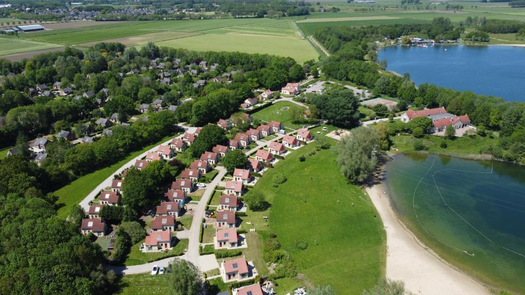 uma vista aérea de uma aldeia com casas e um lago em Vakantiepark 't Broeckhuys em Ewijk