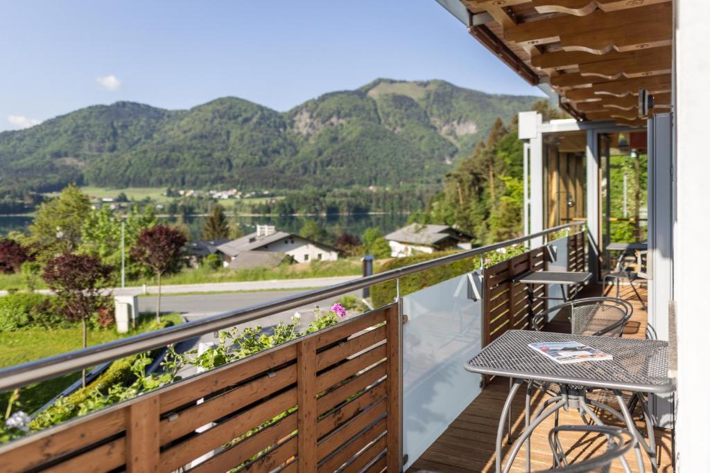 a balcony with a table and chairs and mountains at Haus Bergblick in Fuschl am See