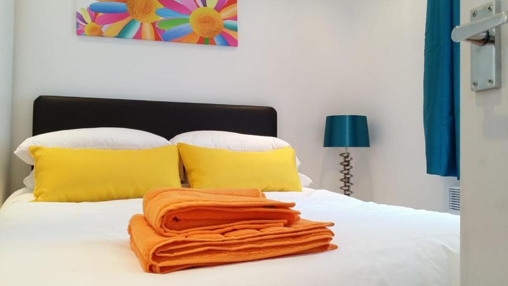 an orange towel is laying on a white bed at The Jorvik Mini studio with Parking in York