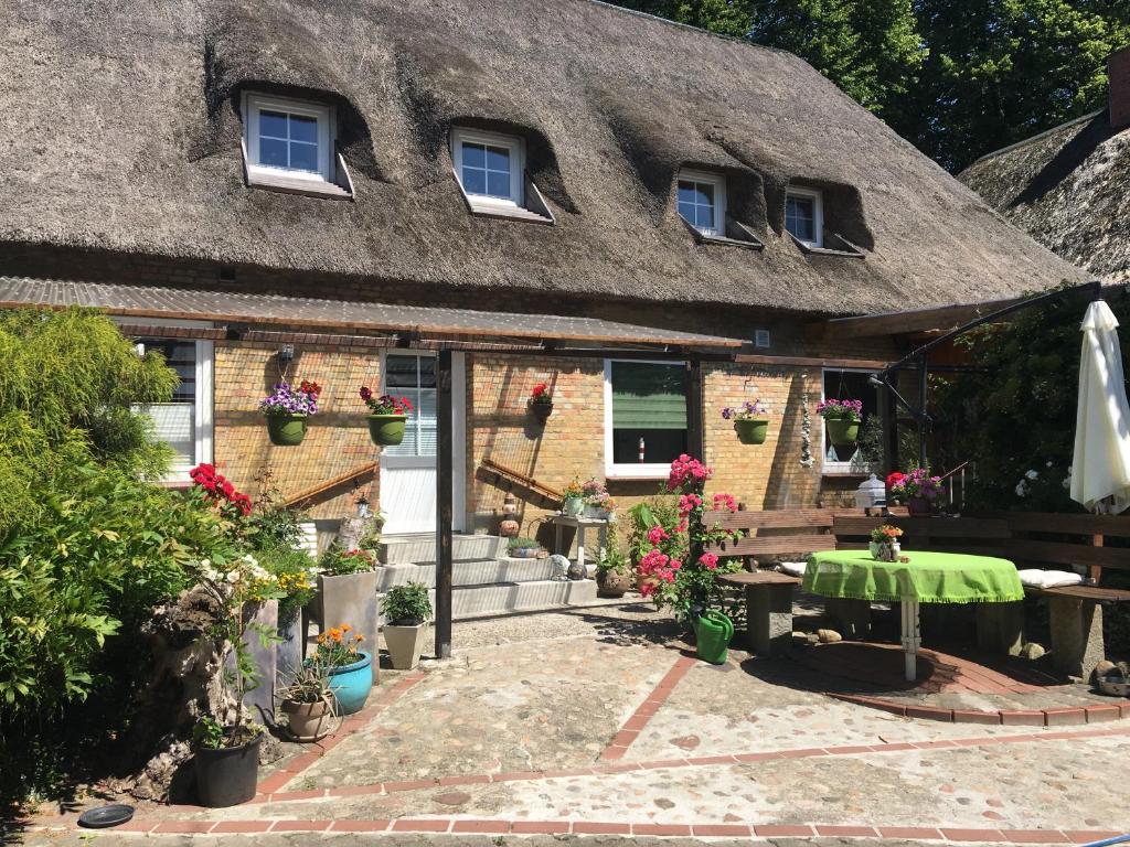 a house with a table and a thatch roof at Kreatives Wohnen unter Reet ruhig und doch zentral in Schwabstedt