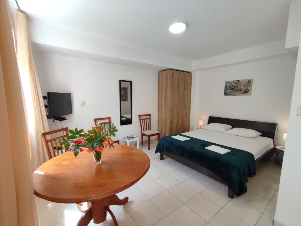 a hotel room with a bed and a table with a table at Studio Apartman Radimir in Kotor