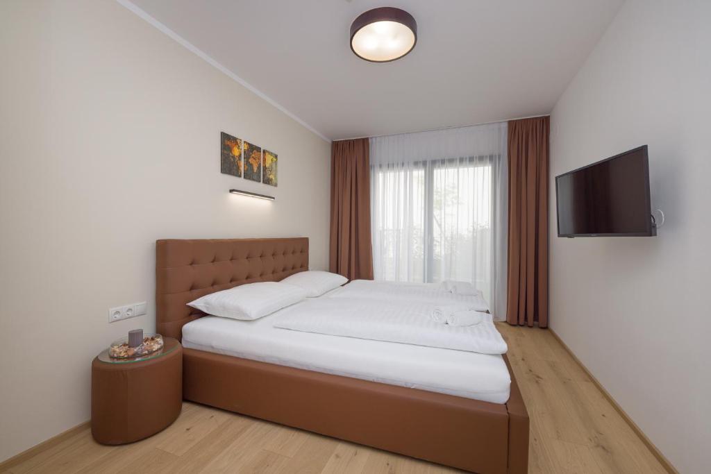 1 dormitorio con 1 cama y TV en la pared en Yourapartment Theresien en Viena