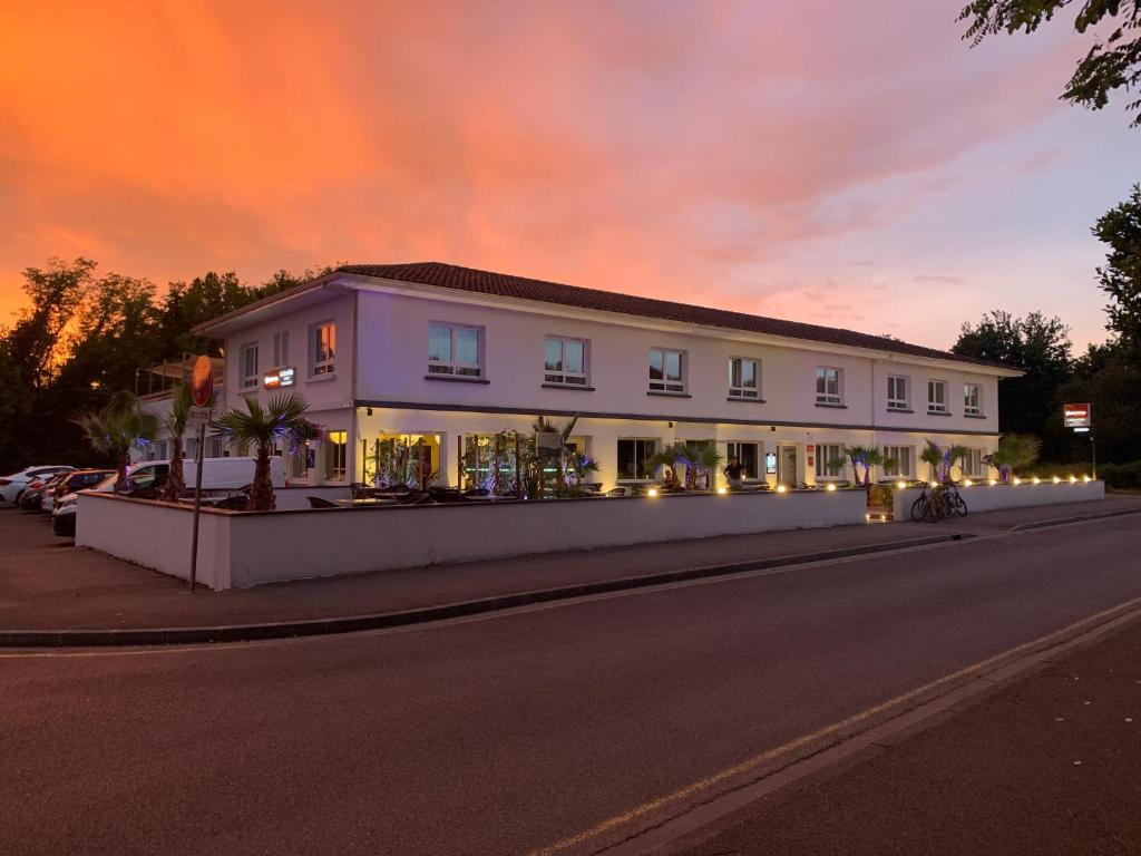 a large white building on the side of a road at The Originals Boutique, Hôtel Lakeside, Biscarrosse , Lac in Parentis-en-Born