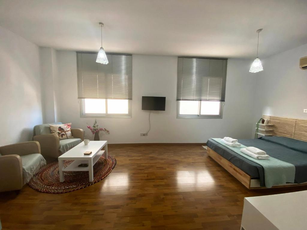 a living room with a bed and a couch at Lovely studio apartment in Pafos in Paphos City