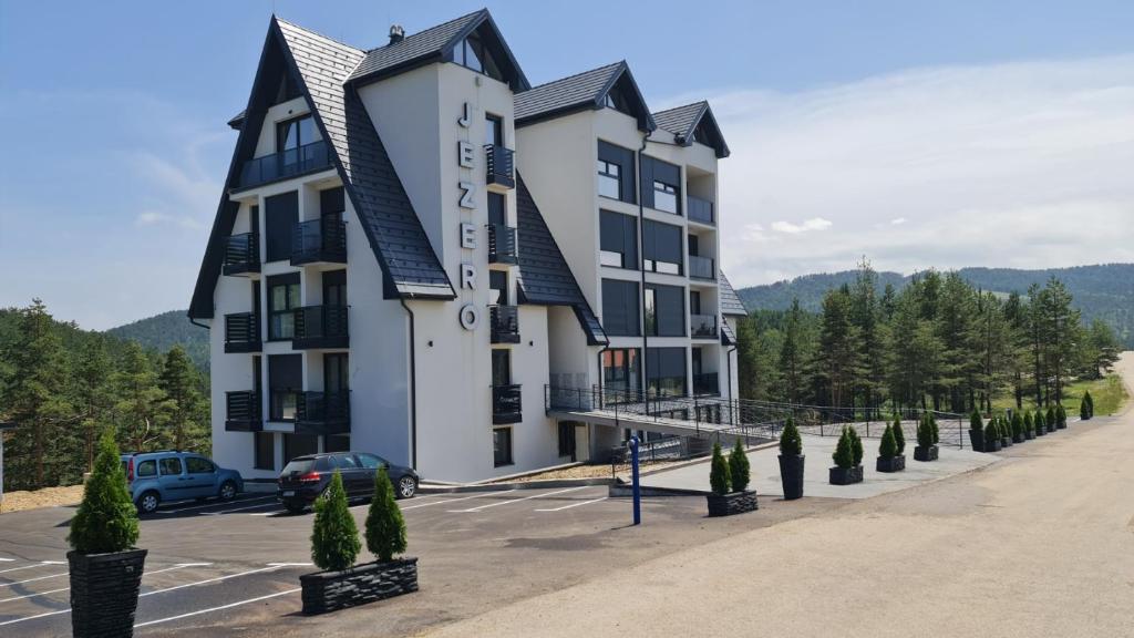 un edificio con un'auto parcheggiata in un parcheggio di Apartman Mina Jezero a Divčibare