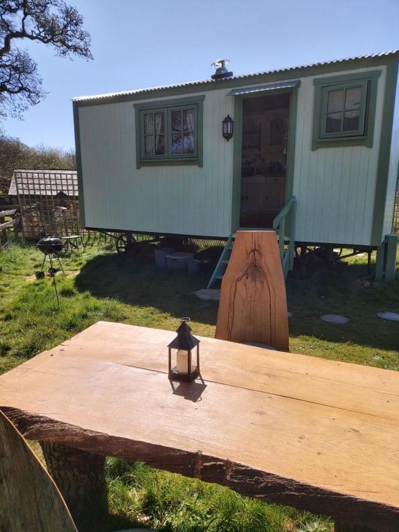 a wooden table in front of a tiny house at The Old Mill Shepherds Hut in Okehampton